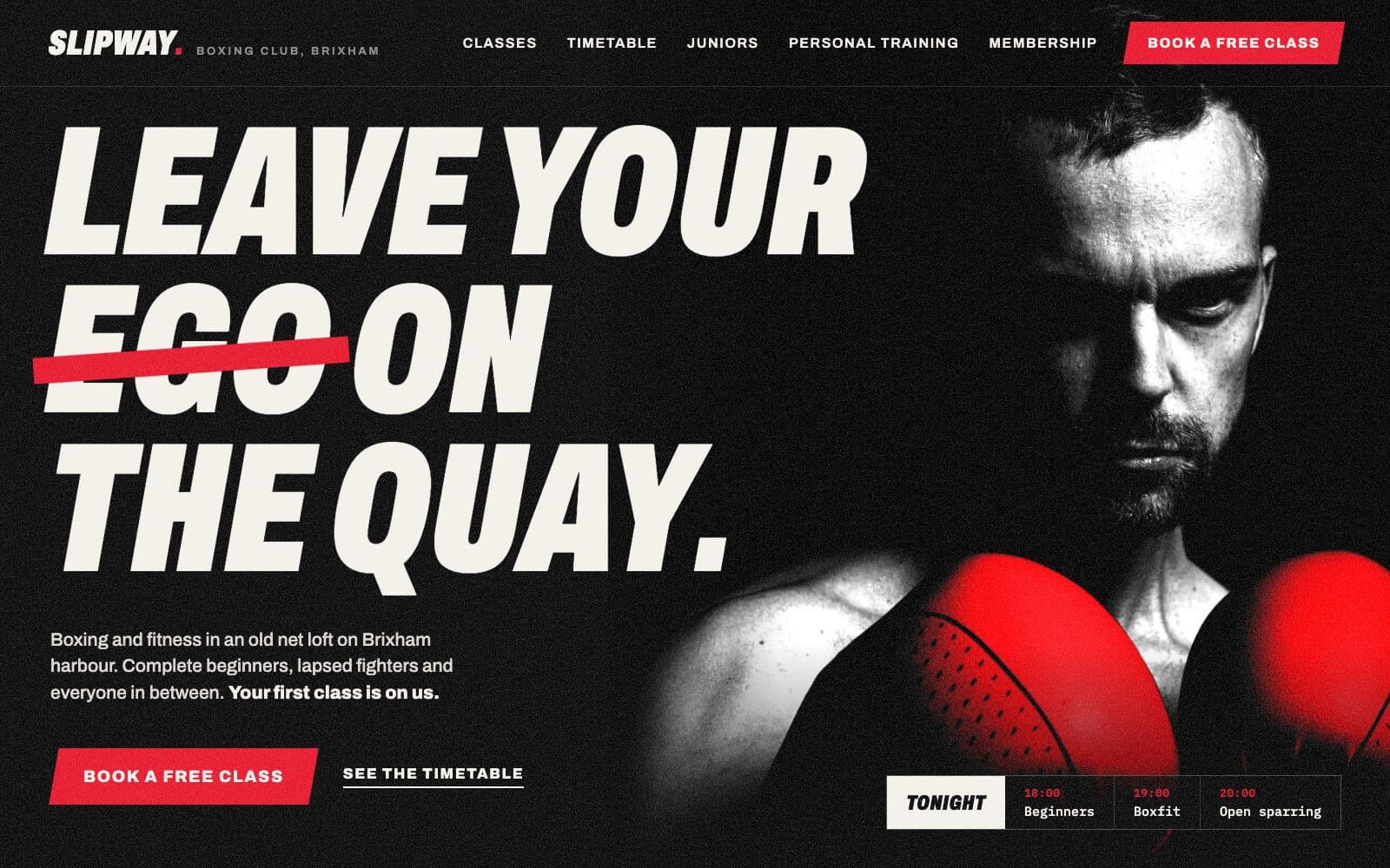 Homepage design for a boxing gym: a black and white boxer with red gloves beside a heavy italic headline, Leave your ego on the quay, with ego struck through in red